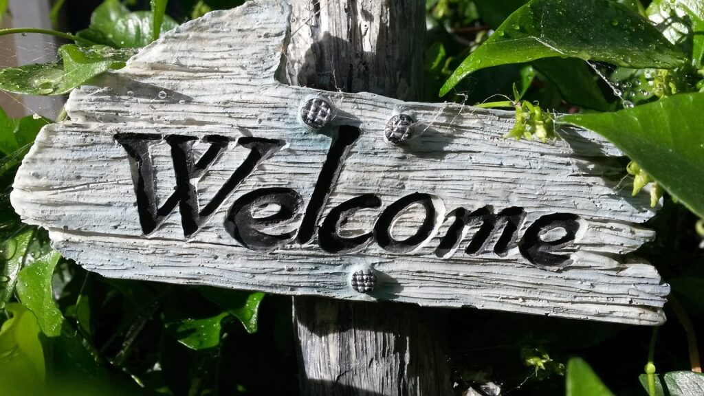 Wooden sign with the word welcome on it.