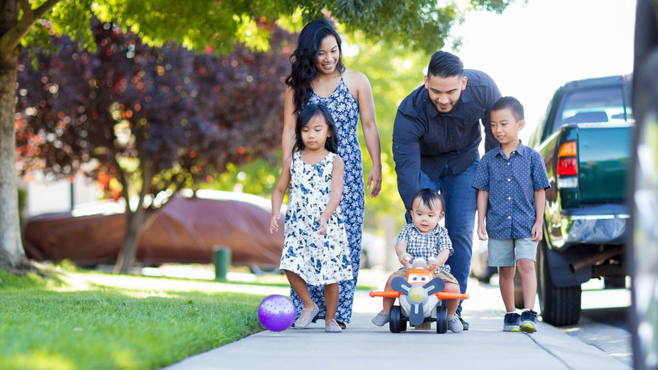Samantha and Albert Diaz walk with their three children down a sunny sidewalk. Samantha earned a bachelor’s degree in psychology, and Albert earned a bachelor’s degree in computer science — both through Oregon State University Ecampus.