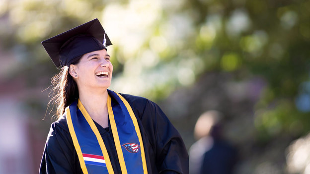 Hope Nelson, Oregon State University Ecampus graduate, standing in her graduation cap and gown