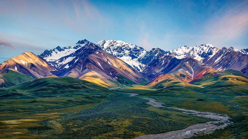 Mountain landscape with snow peaks and winding river highlighting Earth's diverse natural environments.