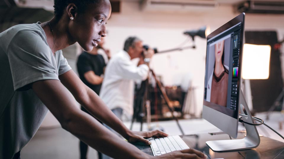 A person editing an image on a desktop computer in a photography studio