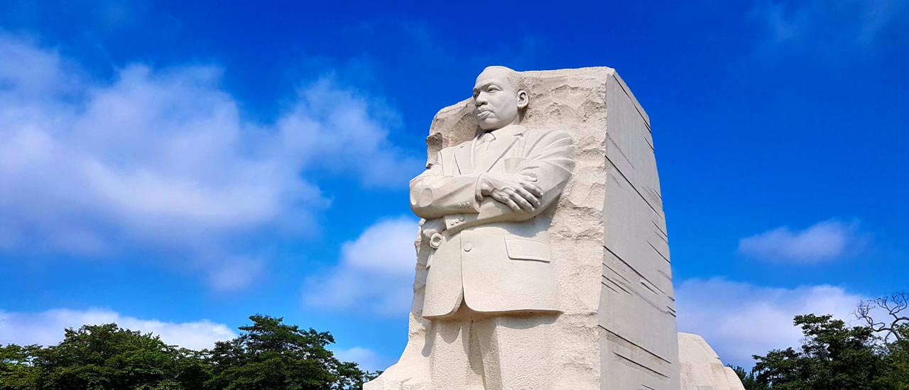 The 30-foot, granite Dr. Martin Luther King, Jr. Memorial statue in Washington, D.C. stands proudly against a blue sky