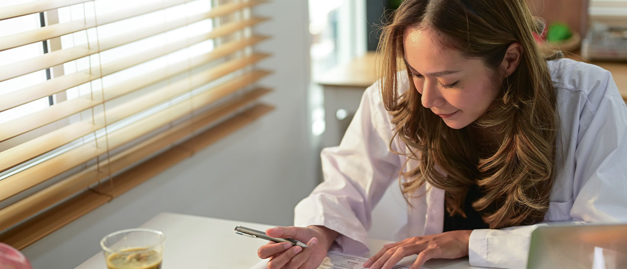 Woman in lab coat studying nutrition data with healthy foods arranged around her