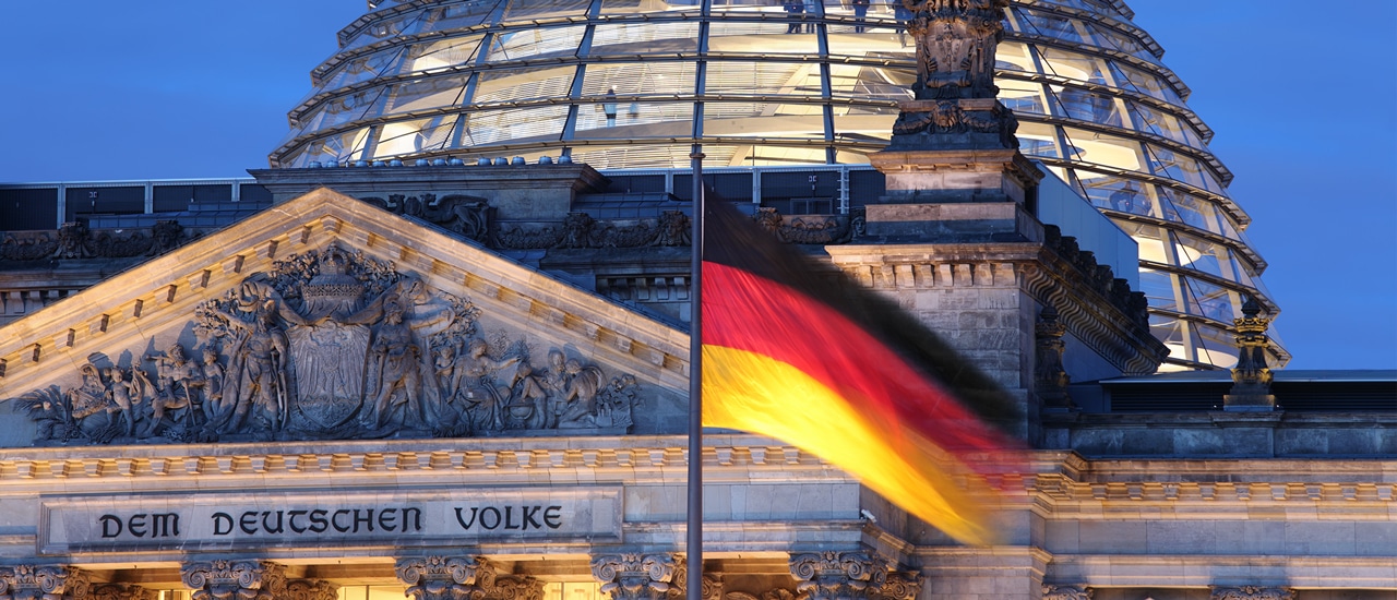 The Reichstag building in Berlin with German flag flying in foreground