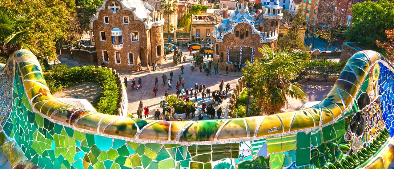 Colorful tile wall in foreground of Parc G&uuml;ell in Barcelona with brightly colored buildings in background