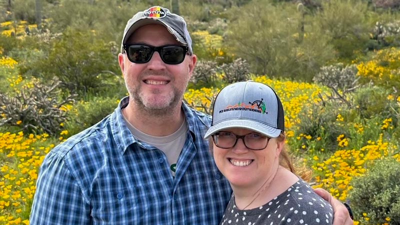 Oregon State student Shane Carwile stands in a field with his wife Heather.