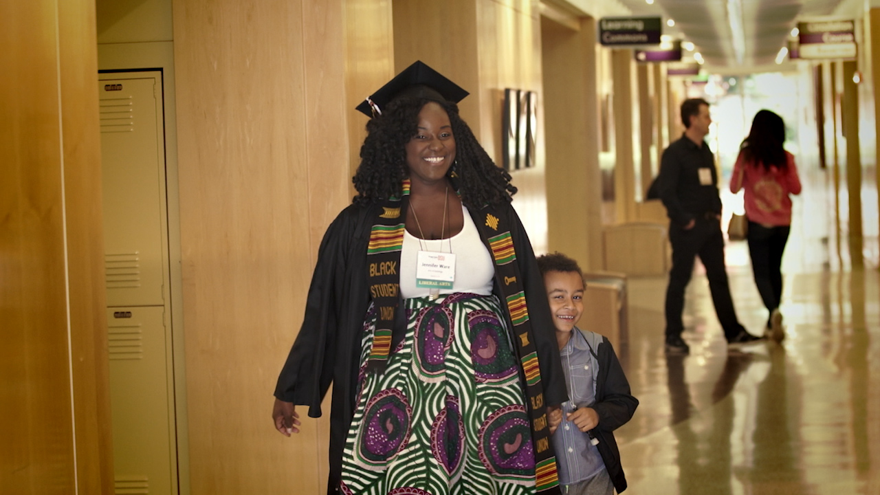 Jennifer Ware walks proudly with her young son holding her hand on her graduation day.