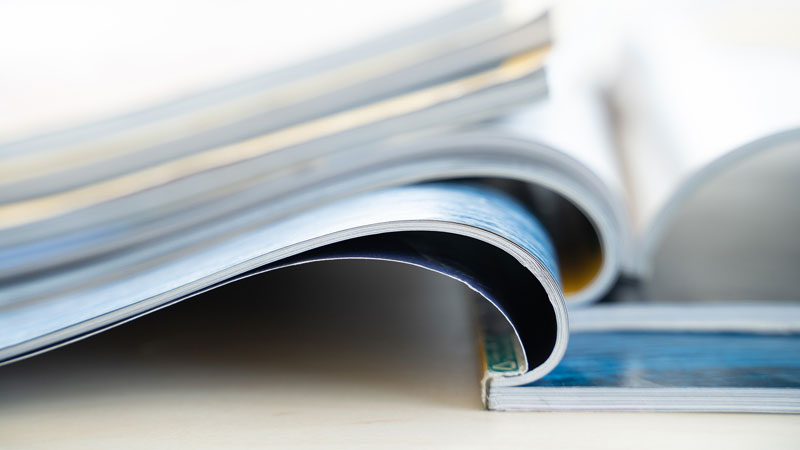 Macro image of magazines open on a table.