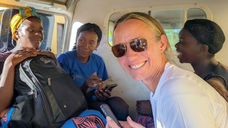 Oregon State University student Elizabeth Blanton smiles at the camera while riding in a van with members of the Chilundika village in Zambia.