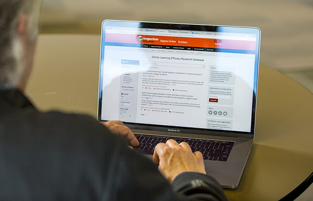 Yvette Gibson, Oregon State Ecampus rangeland sciences instructor, browses OSU's Online Learning Efficacy Research Database on a silver laptop.