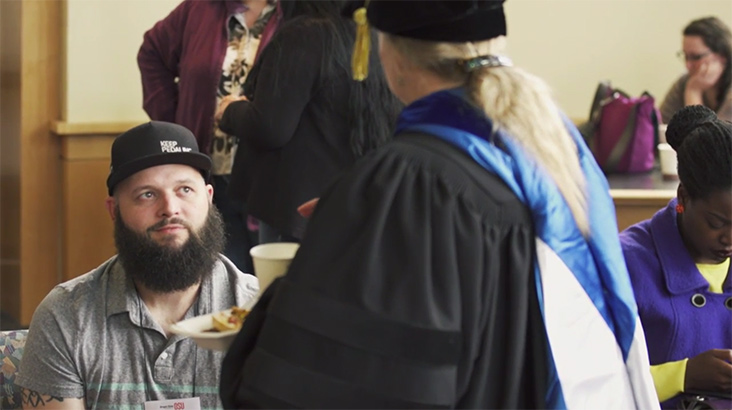 Matthew Baird speaks with an instructor at the Ecampus graduation reception.