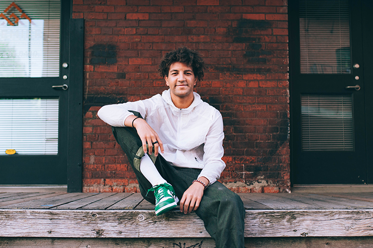 Josh Griffie, a business administration online student with Oregon State University Ecampus, sits on a boardwalk.