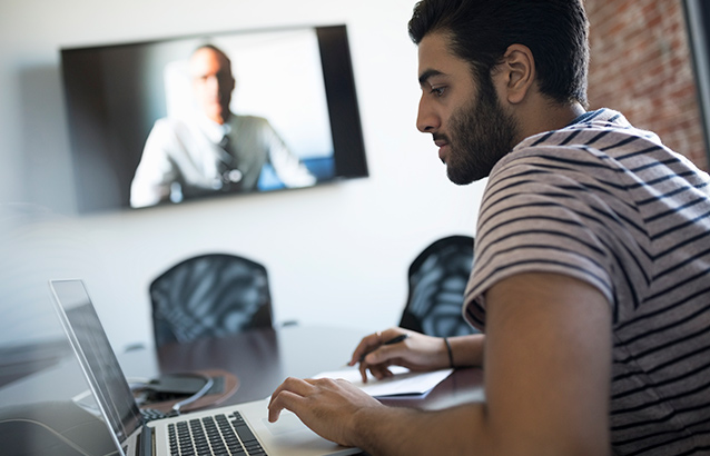 Person at computer while on a teleconference