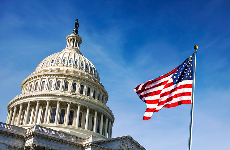 Photo of the U.S. Capitol Building, with the American flag waving in the foreground. Oregon State online political science