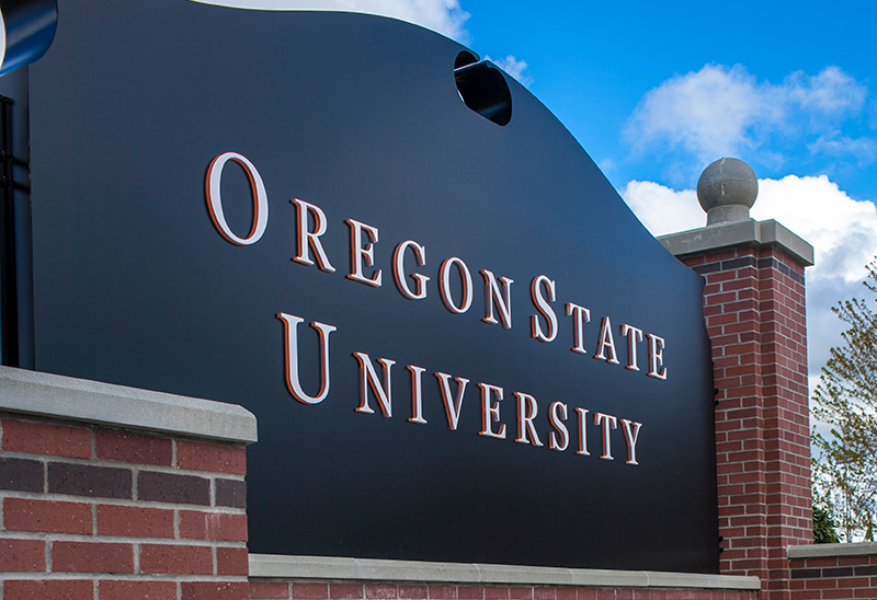 A black sign in gold lettering that reads that Oregon State University, which serves Native and Indigenous students through online education and support